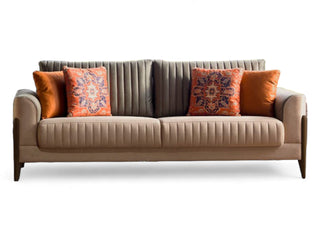 Piero Sleeper Sofa with bold brass button detailing and exposed wooden legs. Features built-in storage and a fold-down sleeper for added convenience.