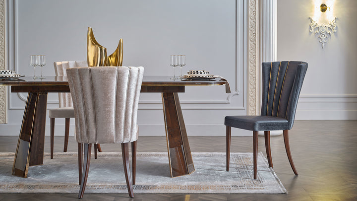 Discover the Plaza Dining Table's sophisticated oval design. Made from engineered wood with a dark brown finish and gold case hardware, this table is a stylish addition to any dining room.